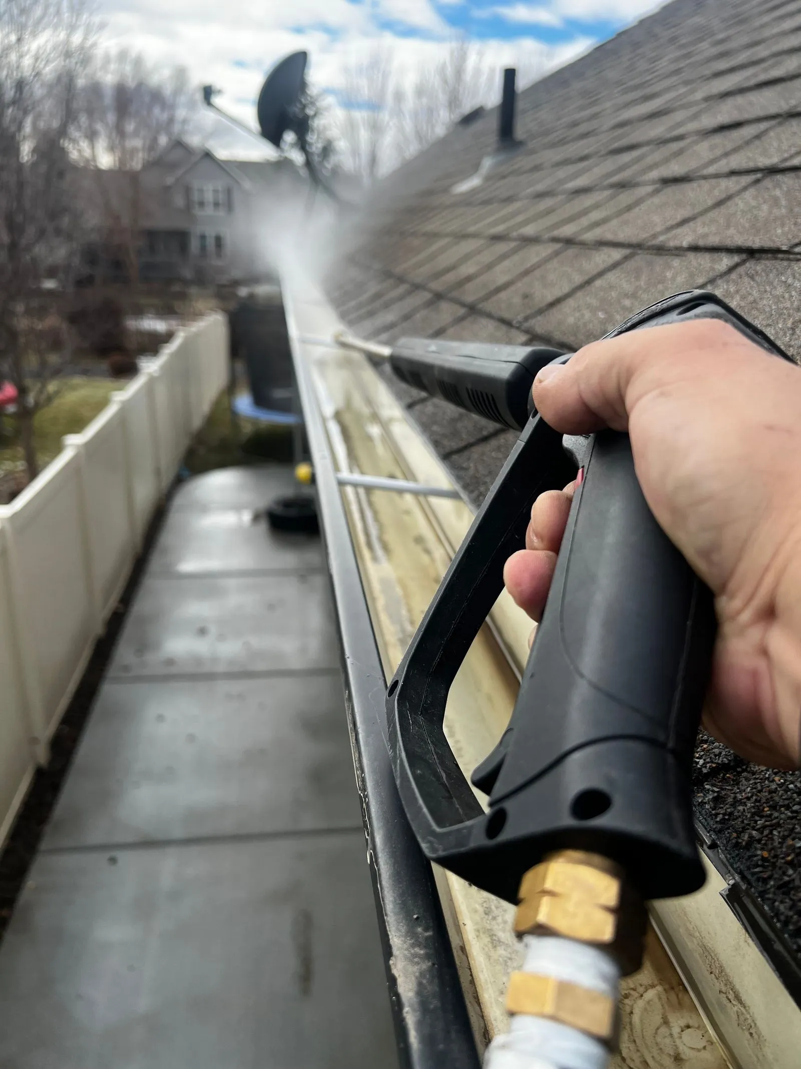 Leaves and debris being cleared out of a house gutter