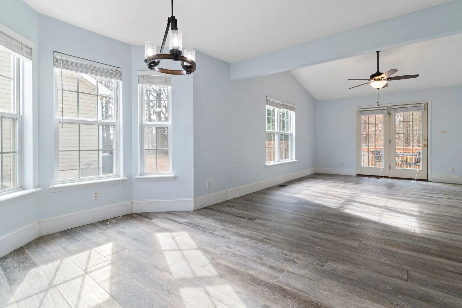 A living room with a ceiling fan and light fixture overhead