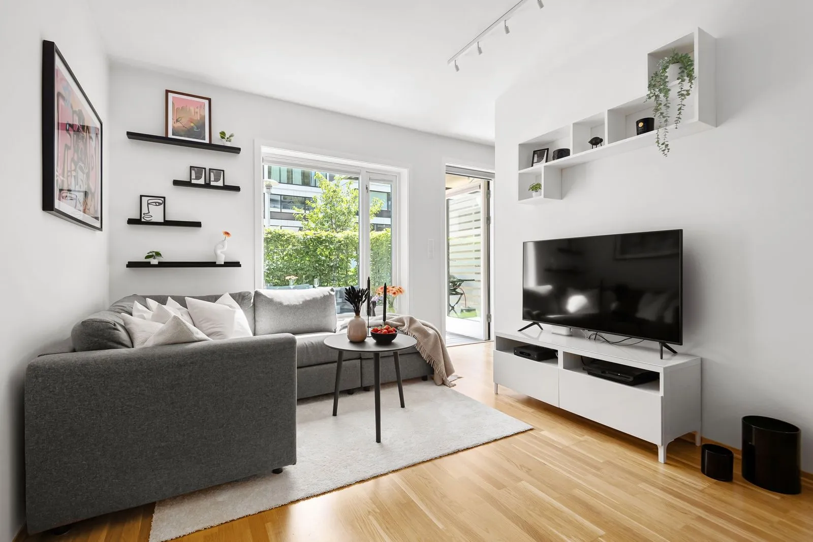 A flat-screen television mounted on the wall of a bright living room